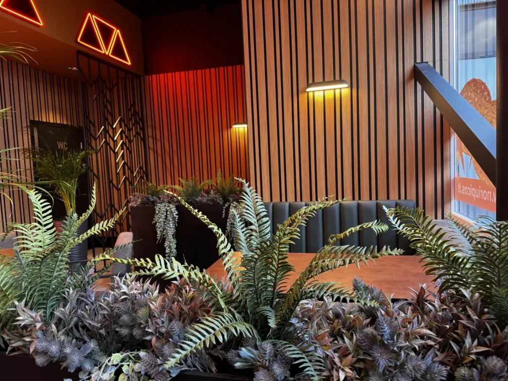 Dekoratyvinių augalų derinys šiltame restorano interjere